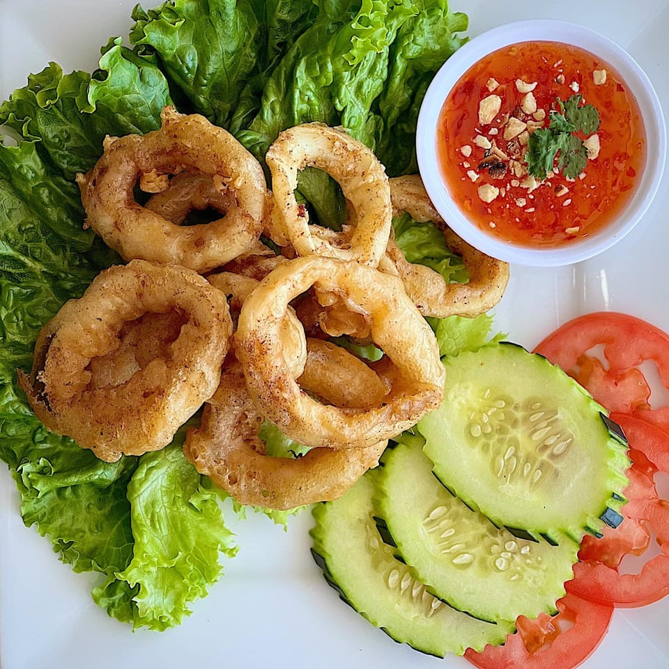 Crispy fried calamari rings with sweet chili sauce, lettuce, cucumber, and tomato slices.